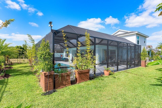 back of house with a lanai, a swimming pool, fence, a yard, and a patio
