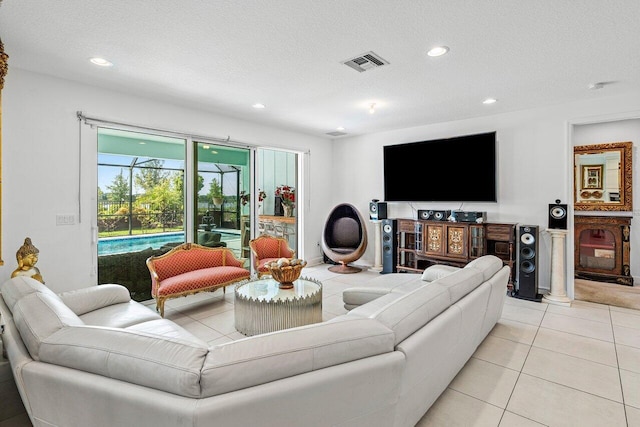living room featuring visible vents, recessed lighting, a textured ceiling, and light tile patterned floors