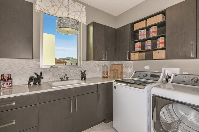 laundry room featuring washer and dryer, a sink, marble finish floor, and cabinet space