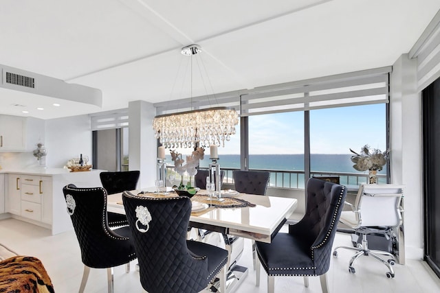 dining space with a water view, a notable chandelier, and visible vents