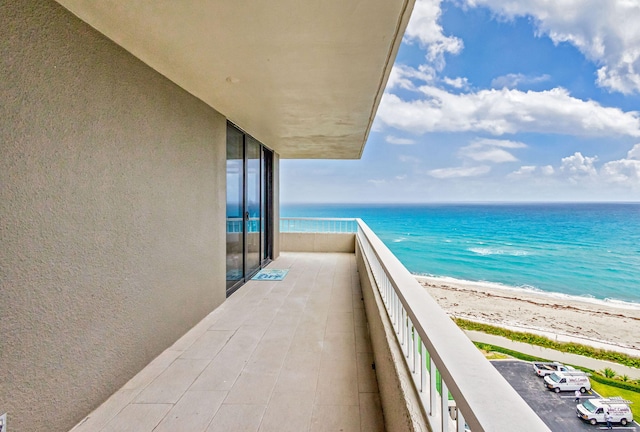 balcony featuring a water view and a view of the beach