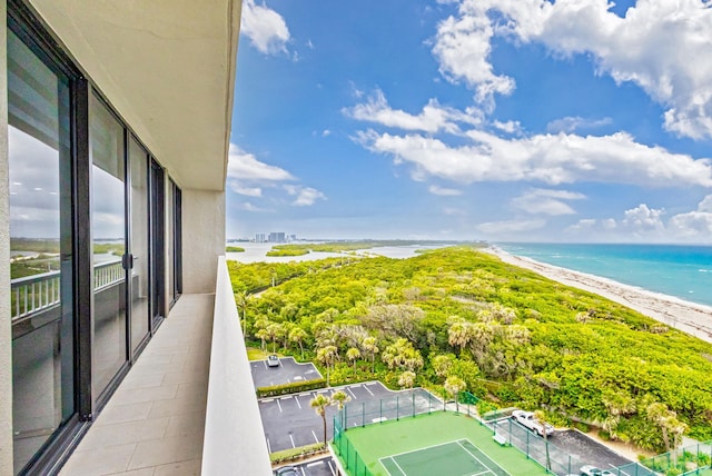 balcony featuring a water view and a view of the beach