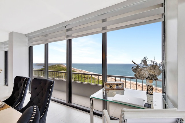 interior space with a water view, a wealth of natural light, and a beach view