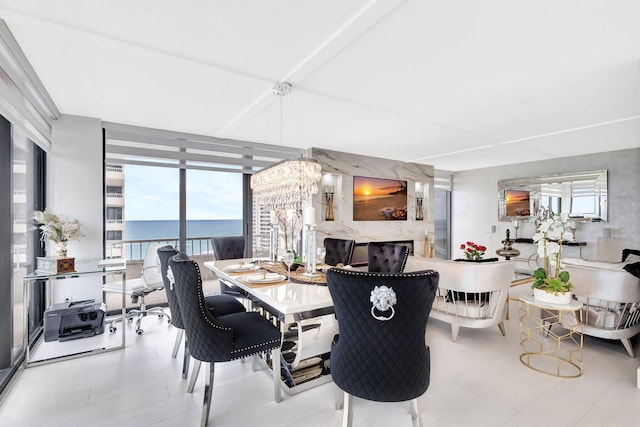 dining area featuring an inviting chandelier, a water view, and floor to ceiling windows