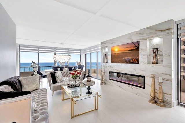 living room with a notable chandelier, a wall of windows, plenty of natural light, and a fireplace