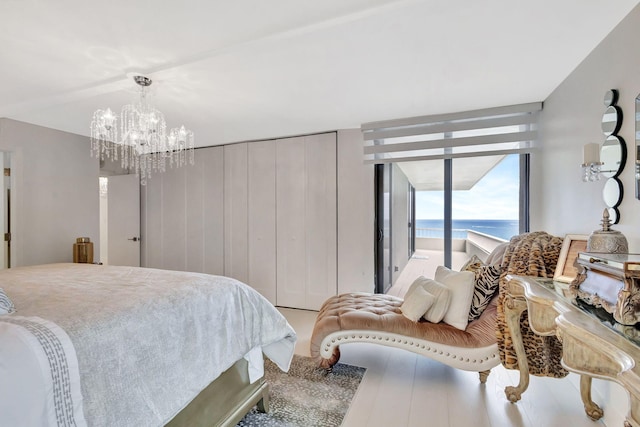 bedroom with a wall of windows, a chandelier, and access to exterior