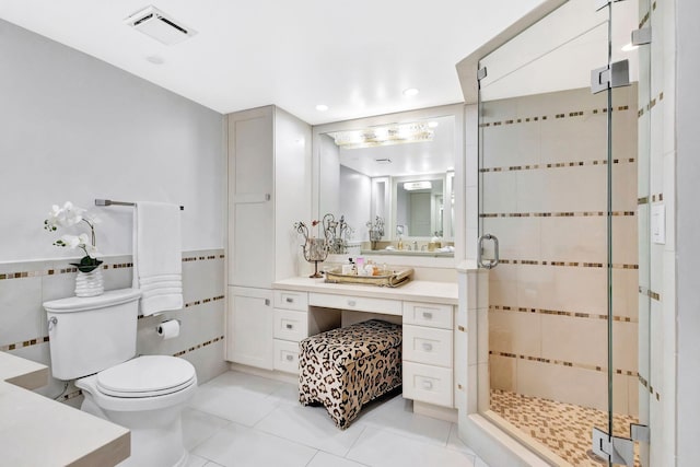 bathroom with visible vents, toilet, tile walls, tile patterned floors, and a shower stall