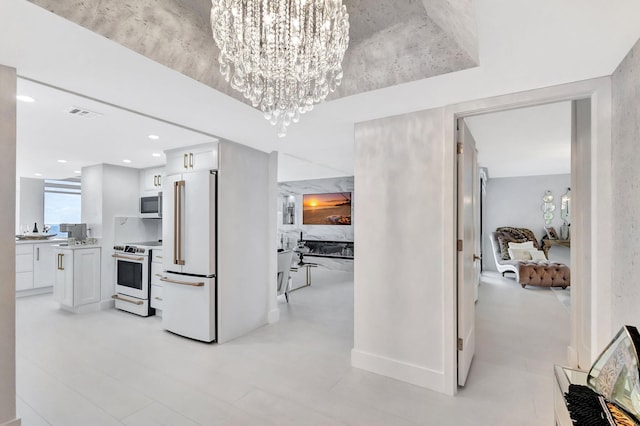 hall featuring visible vents and a notable chandelier