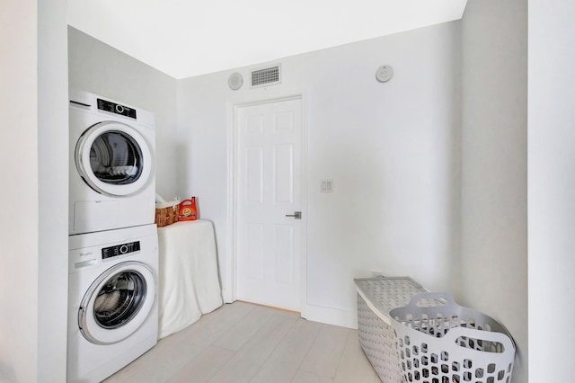 laundry area featuring stacked washer and dryer, laundry area, and visible vents