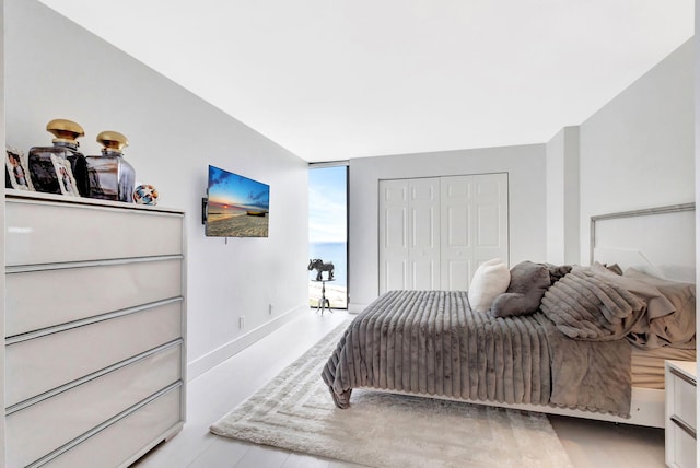bedroom featuring a closet, floor to ceiling windows, and baseboards