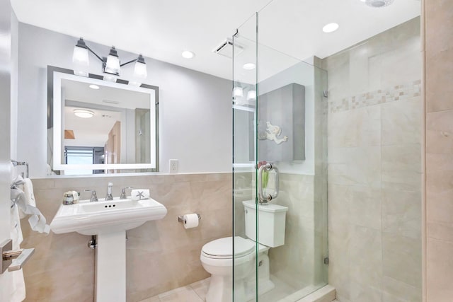 bathroom with visible vents, tile patterned flooring, toilet, tile walls, and a shower stall