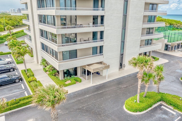 view of building exterior featuring a water view and uncovered parking