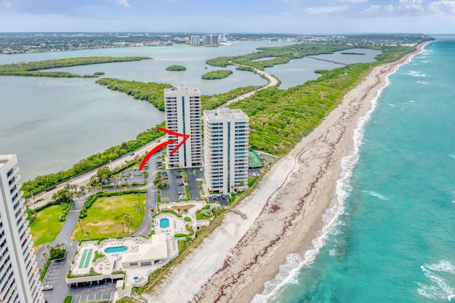 birds eye view of property with a water view and a beach view