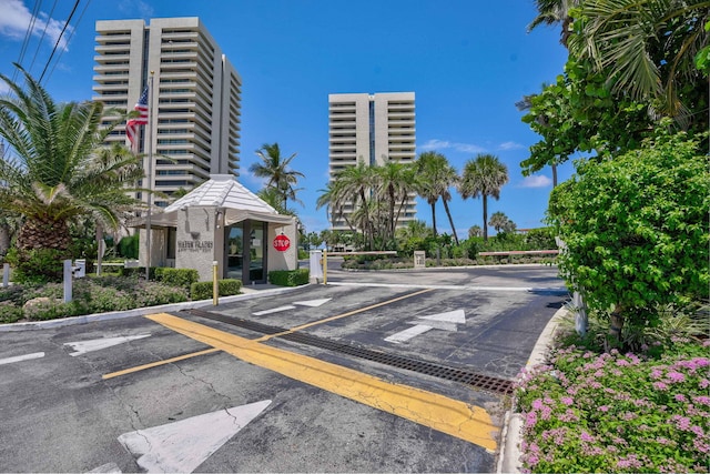view of street with traffic signs, a gated entry, and curbs