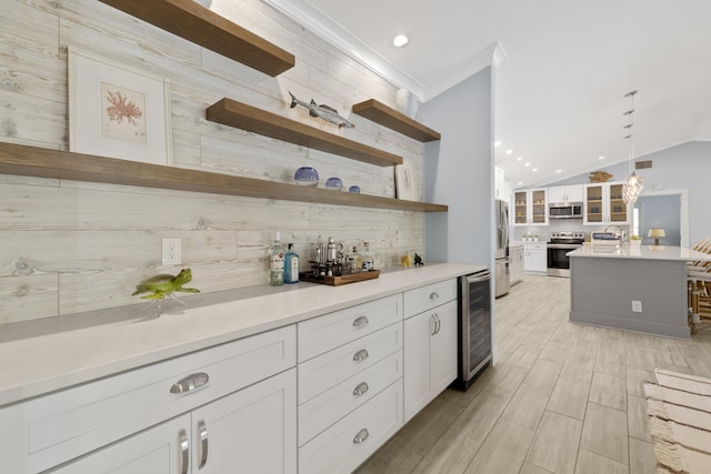 bar area featuring appliances with stainless steel finishes, beverage cooler, decorative backsplash, lofted ceiling, and pendant lighting