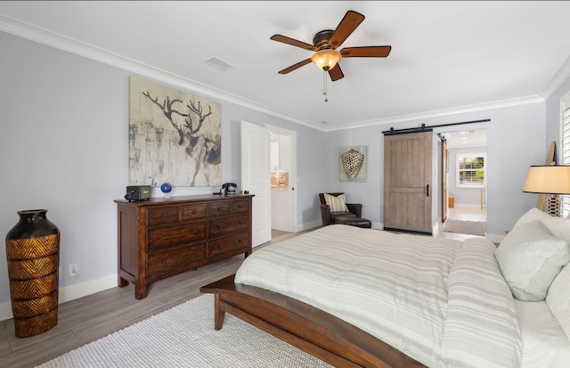 bedroom featuring ornamental molding, wood finished floors, baseboards, a barn door, and ceiling fan
