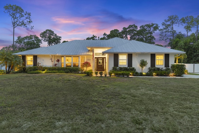 ranch-style home with metal roof, a standing seam roof, and stucco siding
