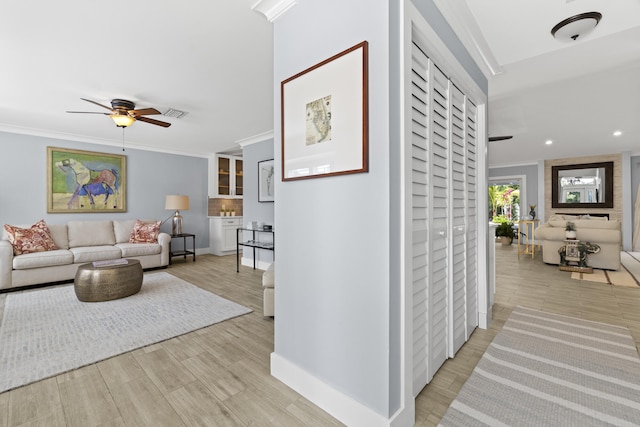 living area featuring ceiling fan, crown molding, baseboards, light wood finished floors, and recessed lighting
