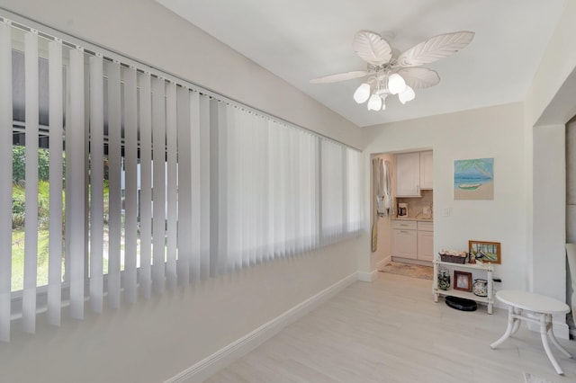 corridor featuring baseboards and a wealth of natural light