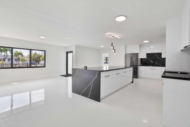 20685 NE 2nd Ave, Miami, FL 33179 - kitchen with a healthy amount of sunlight, dark countertops, modern cabinets, freestanding refrigerator, and white cabinetry