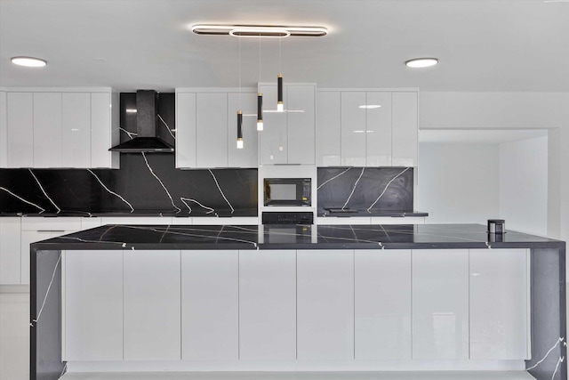 20685 NE 2nd Ave, Miami, FL 33179 - kitchen with wall chimney range hood, dark countertops, black microwave, white cabinetry, and modern cabinets