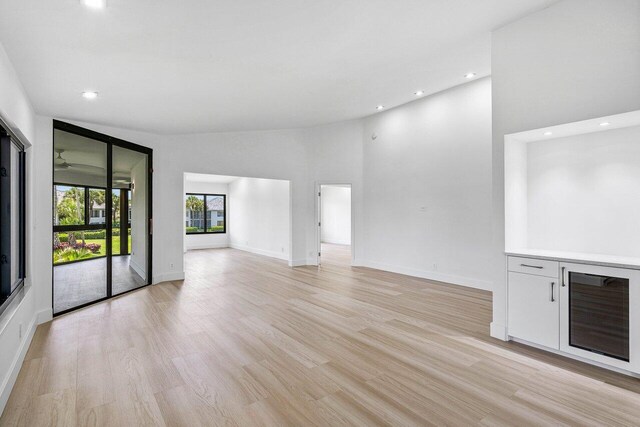 15687 Loch Maree Ln Unit 2404, Delray Beach, FL 33446 - unfurnished living room featuring recessed lighting, baseboards, light wood-type flooring, and a high ceiling