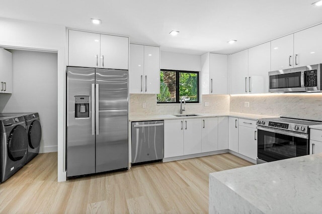 15687 Loch Maree Ln Unit 2404, Delray Beach, FL 33446 - kitchen with washer and clothes dryer, stainless steel appliances, light wood-type flooring, light countertops, and recessed lighting