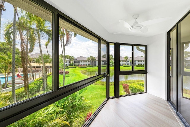 15687 Loch Maree Ln Unit 2404, Delray Beach, FL 33446 - unfurnished sunroom featuring ceiling fan, a water view, wood finished floors, and baseboards