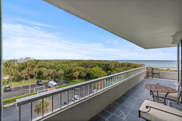 balcony with a water view and a forest view