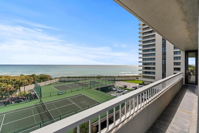 balcony with a water view and a tennis court