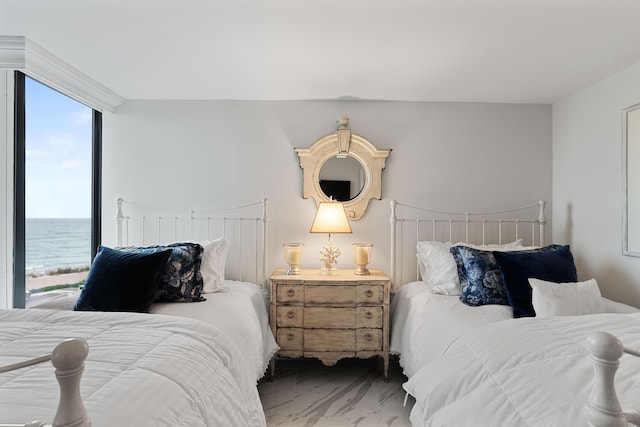 bedroom featuring a water view and marble finish floor
