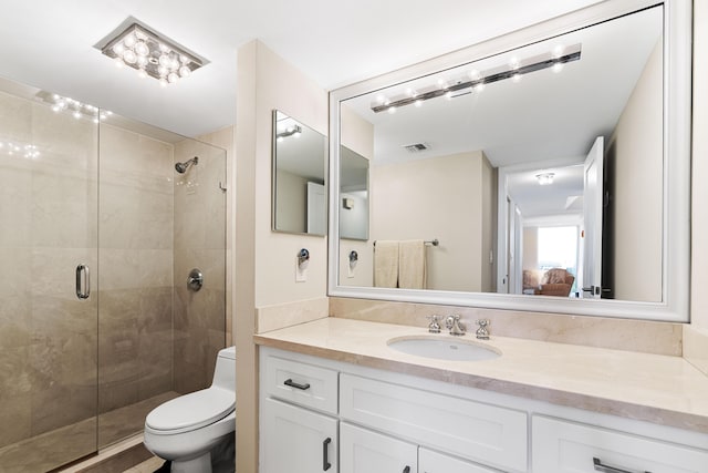 ensuite bathroom with vanity, a stall shower, toilet, and visible vents