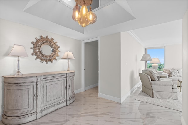 hallway featuring baseboards, a tray ceiling, and marble finish floor