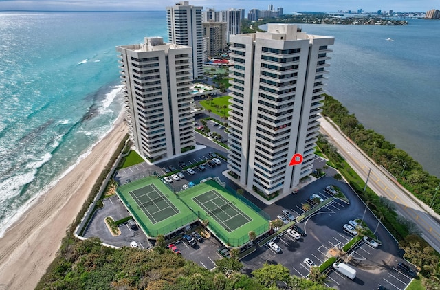 drone / aerial view with a city view, a beach view, and a water view