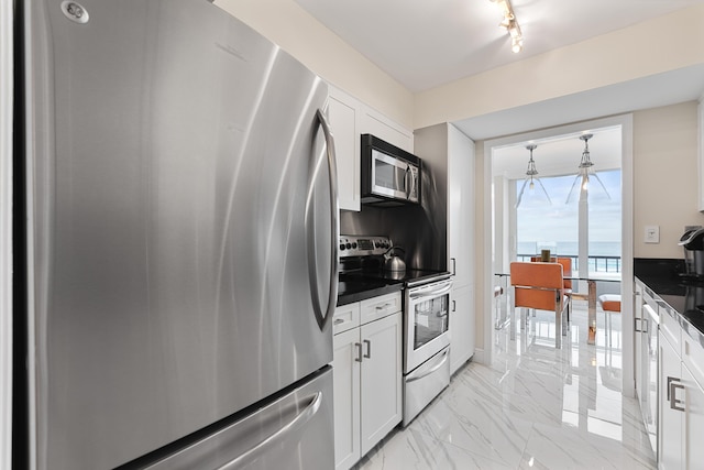 kitchen featuring white cabinets, stainless steel appliances, and dark countertops