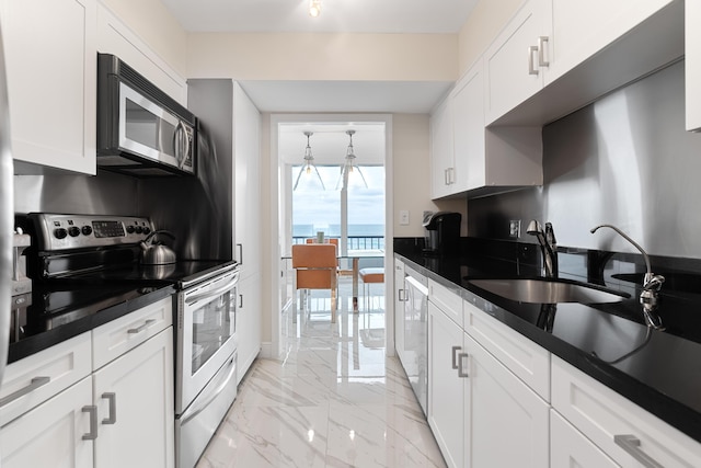 kitchen with white cabinetry, marble finish floor, dark countertops, and stainless steel appliances