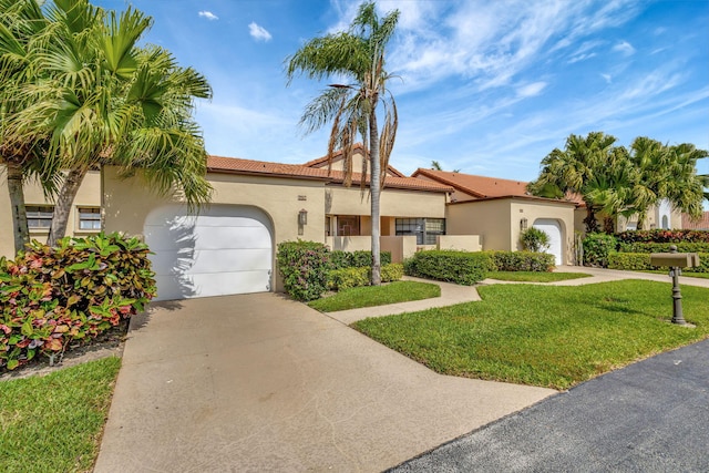 mediterranean / spanish home featuring an attached garage, concrete driveway, and stucco siding