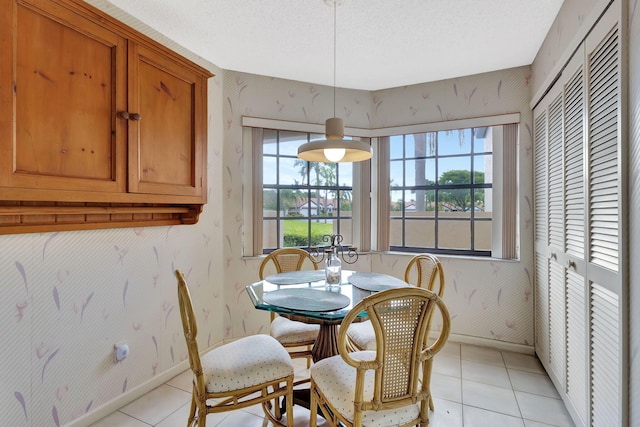 dining space featuring light tile patterned flooring, wallpapered walls, and baseboards