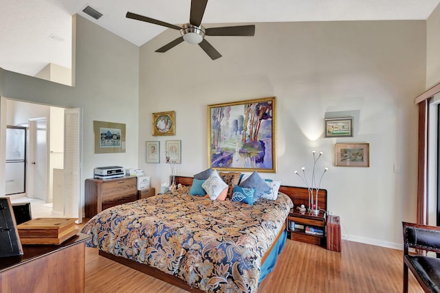 bedroom featuring visible vents, wood finished floors, baseboards, ceiling fan, and high vaulted ceiling