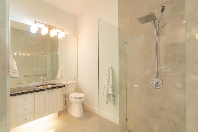 full bathroom with a marble finish shower, vanity, and toilet