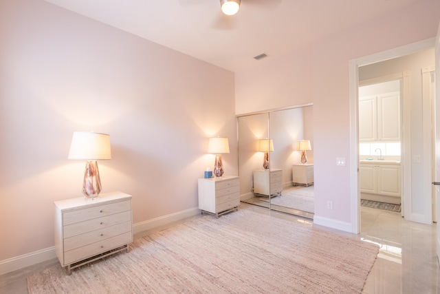 bedroom featuring a ceiling fan, baseboards, visible vents, and a sink
