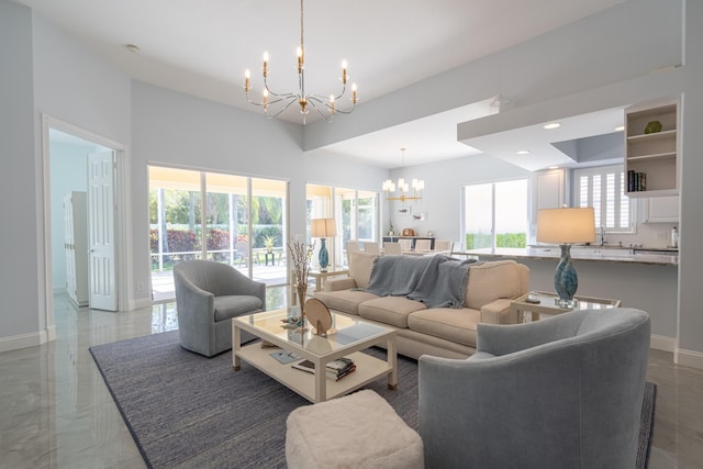 living area featuring plenty of natural light, baseboards, and a notable chandelier