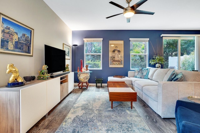 living area with baseboards, ceiling fan, and wood finished floors