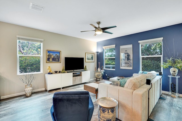 living room with baseboards, ceiling fan, visible vents, and wood finished floors