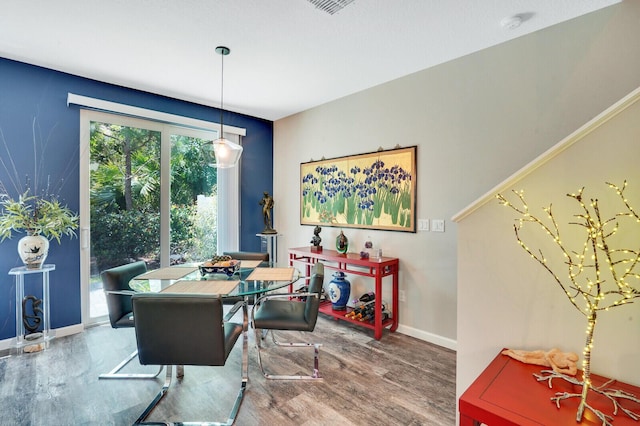 dining area featuring baseboards, wood finished floors, and visible vents