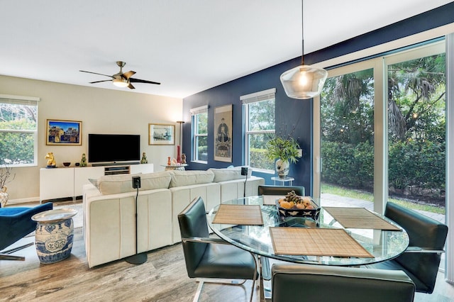 dining room with a ceiling fan, baseboards, and wood finished floors