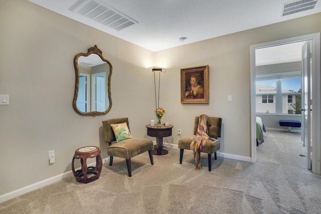 living area featuring baseboards, carpet flooring, and visible vents
