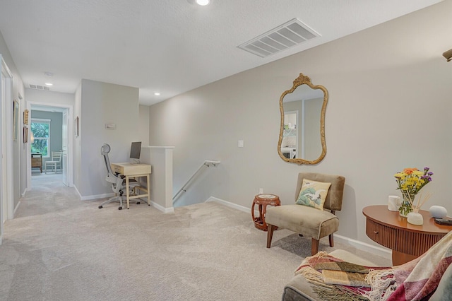 living area with carpet floors, baseboards, visible vents, and an upstairs landing