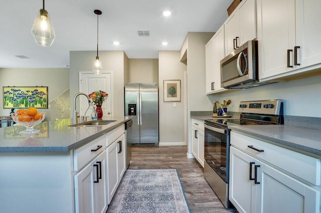 kitchen featuring white cabinets, stainless steel appliances, a sink, and dark wood-type flooring