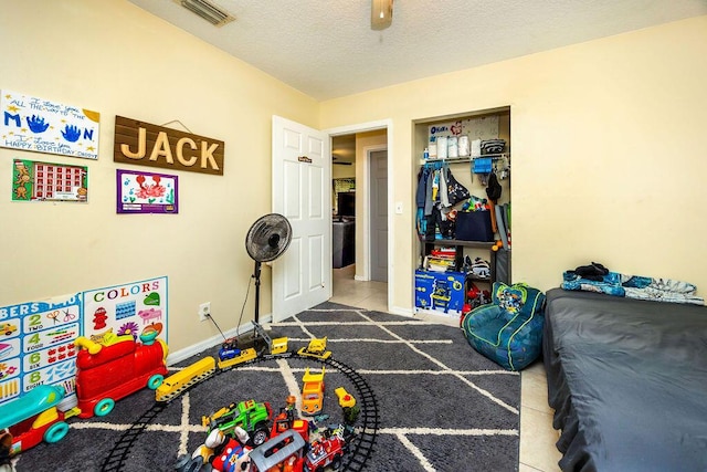 recreation room with a textured ceiling, baseboards, and visible vents